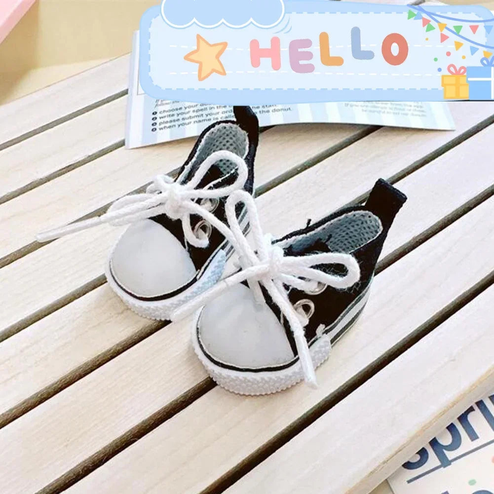 A pair of black casual sneakers with white laces and white soles resting on a wooden surface.