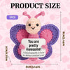 A handmade crochet butterfly doll with pink and purple wings and a motivational card.
