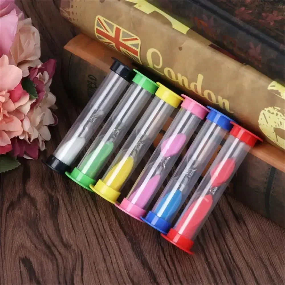 A set of six colorful hourglass sand timers with various durations, resting on a wooden surface next to a book.