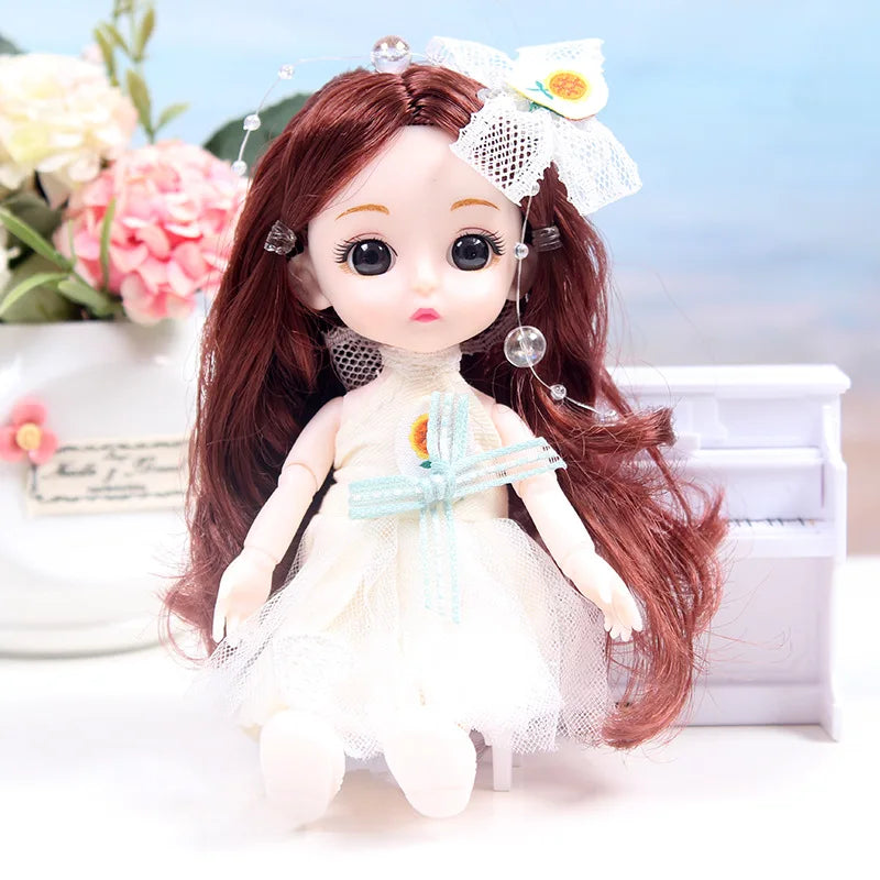 A 17cm articulated princess doll with long reddish-brown hair wearing a white dress and floral accessories.