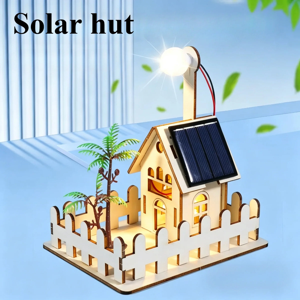 A wooden model kit of a solar hut with a solar panel and a light, set in a fenced outdoor scene.