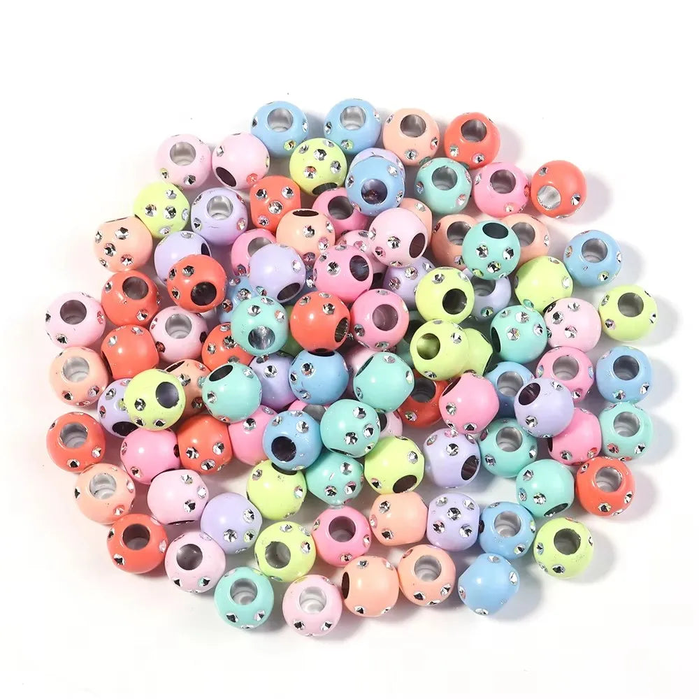 A collection of colorful rhinestone acrylic spacer beads in various shades of pink, green, yellow, and blue.