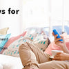 A man is relaxing and playing with a blue fidget toy while sitting on a couch.