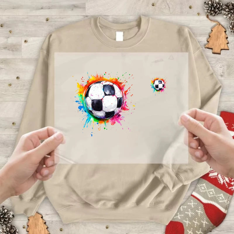 A beige sweatshirt displaying a colorful soccer ball splash art design on the front.