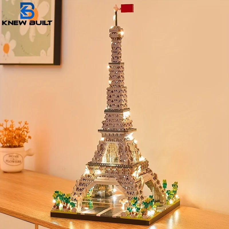 An LED-illuminated model of the Eiffel Tower built from micro building blocks displayed on a wooden surface.