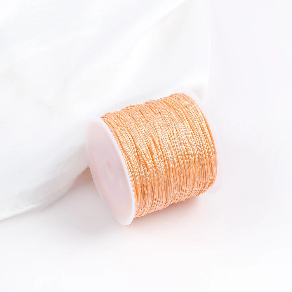 A roll of bright orange 0.8mm cotton nylon macrame cord for jewelry making and crafts.