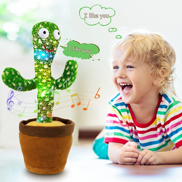A smiling green cactus plush toy with lights and music notes next to a laughing toddler.