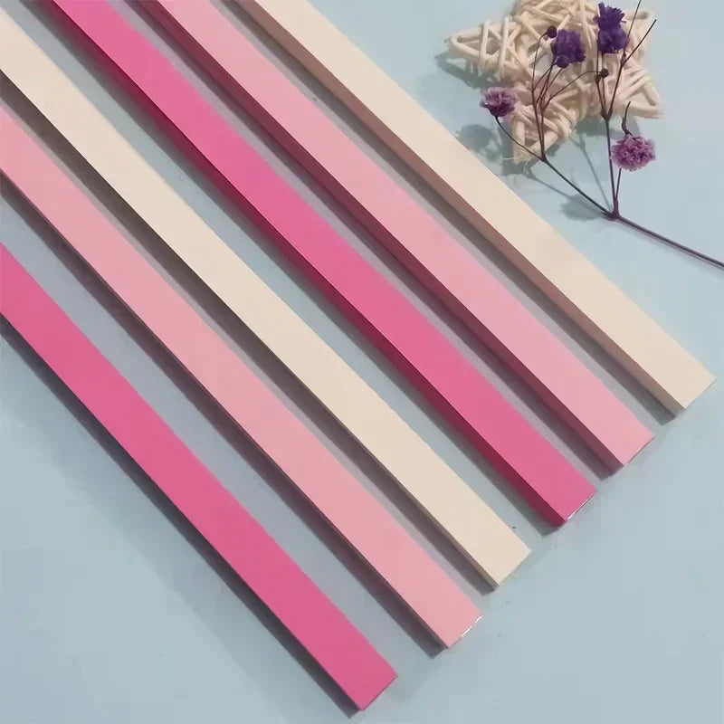 Pink and beige rectangular strips laid diagonally on a light blue surface with purple floral accents.