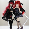 A collectible figure of a girl with long red hair and black gothic attire, featuring intricate details and a dramatic pose.