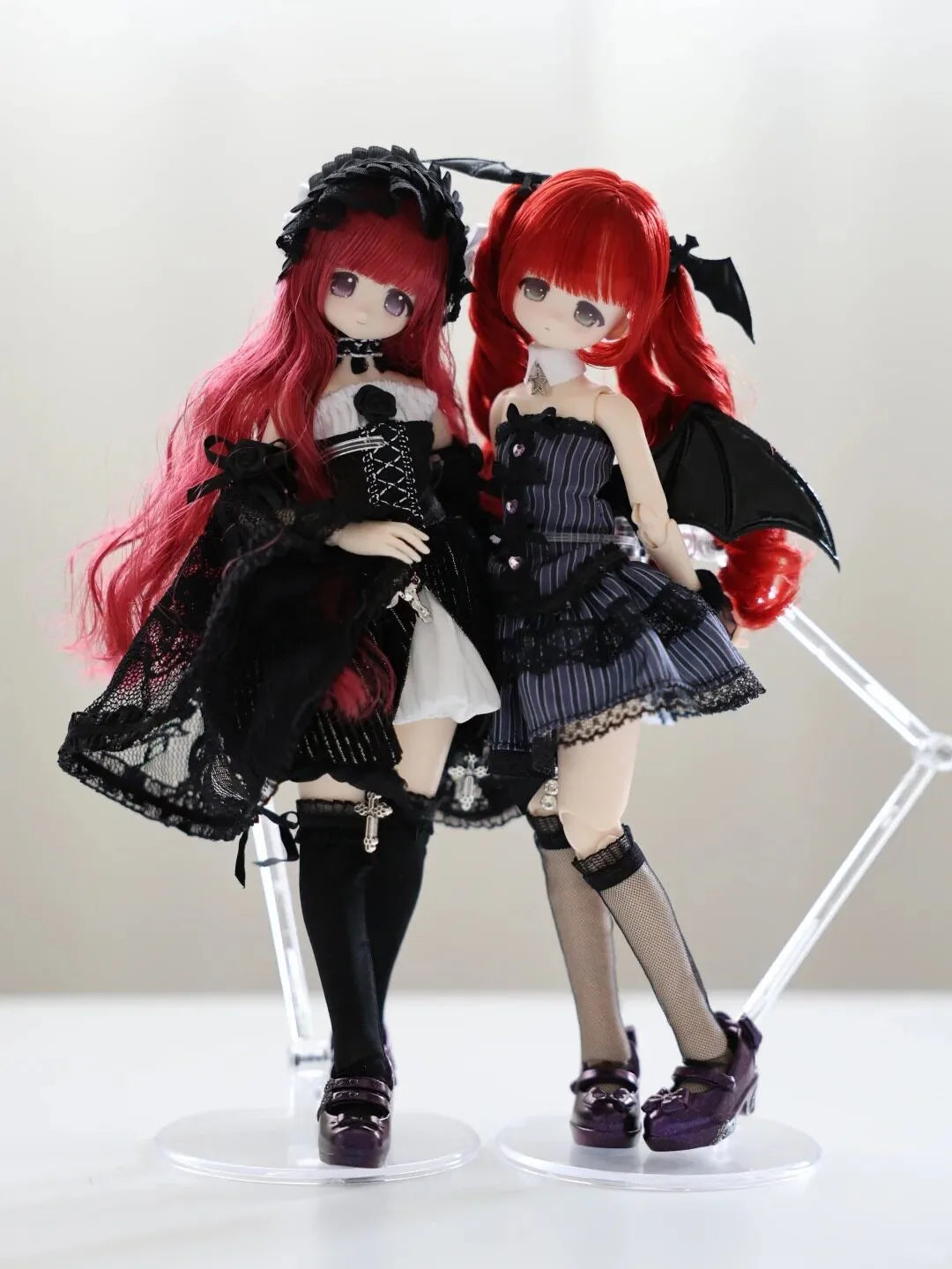 A collectible figure of a girl with long red hair and black gothic attire, featuring intricate details and a dramatic pose.