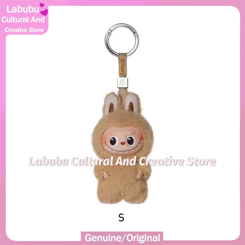 A small, fluffy brown Labubu plush doll with large ears is attached to a silver keyring.