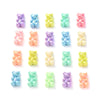 A grid of 16 pastel bear-shaped acrylic craft beads in various shades of purple, blue, pink, and yellow.