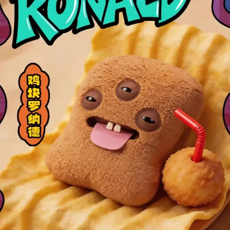 A brown plush toy shaped like an ugly fried chicken nugget monster with a pink tongue, resting on yellow fabric.