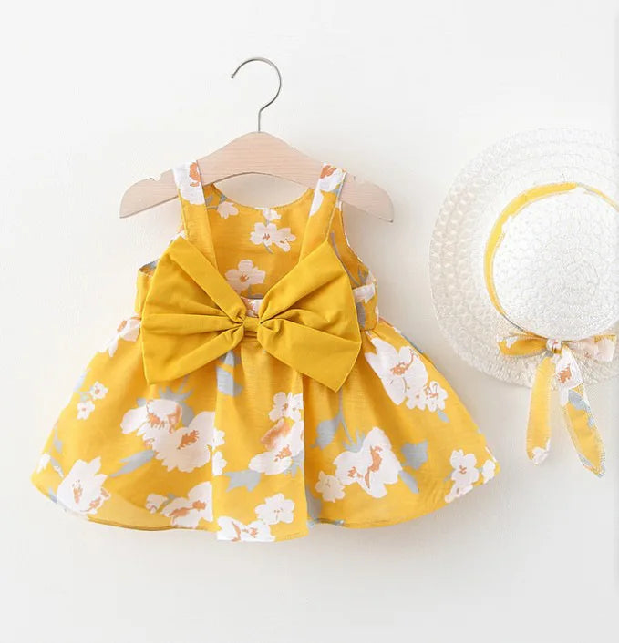 A yellow floral dress for a baby girl with a bow and a white sunhat