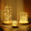 A display of battery-powered fairy lights in glass globes, illuminating warm golden light.