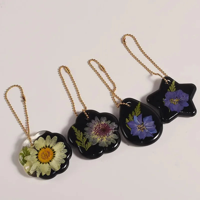 Gold-chained heart-shaped silicone molds for resin jewelry making featuring floral designs.