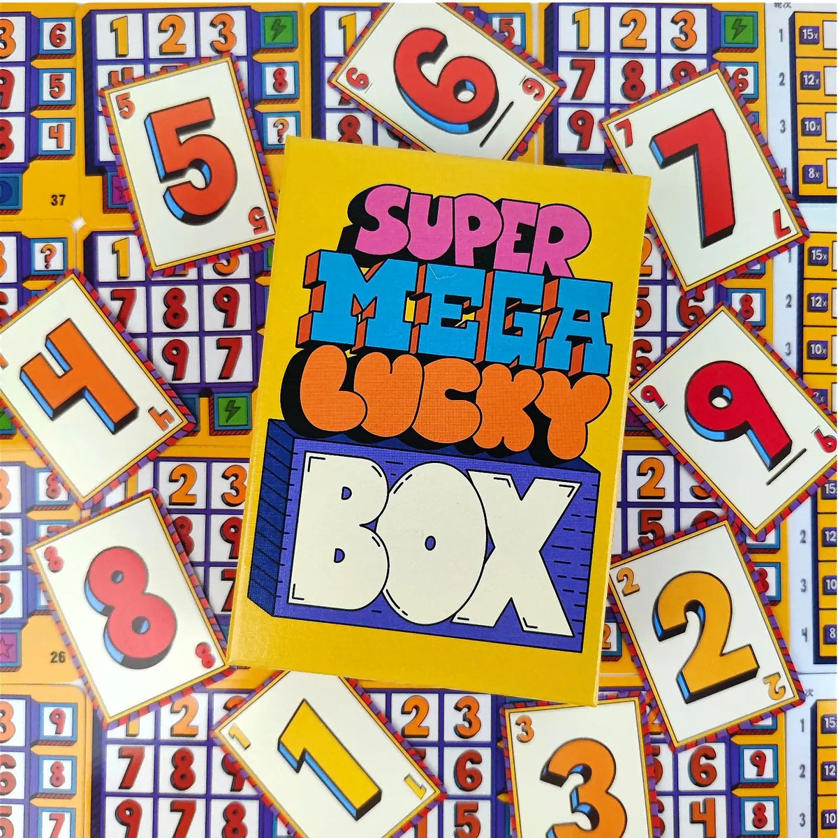 A yellow box for the Super Mega Lucky Box board game surrounded by various numbered cards.
