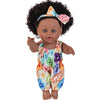 A 12-inch realistic African American baby doll with curly hair wearing a floral patterned outfit and a bow