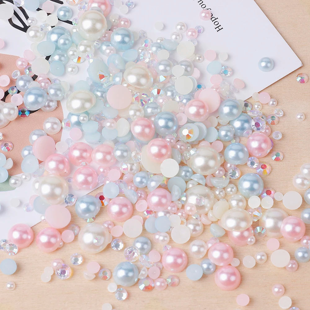 A scattered collection of mixed resin rhinestone pearls with an AB finish in various shades of pink, blue, and white.