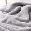 A soft gray hooded animal bath towel is draped and folded, showing its fluffy texture.