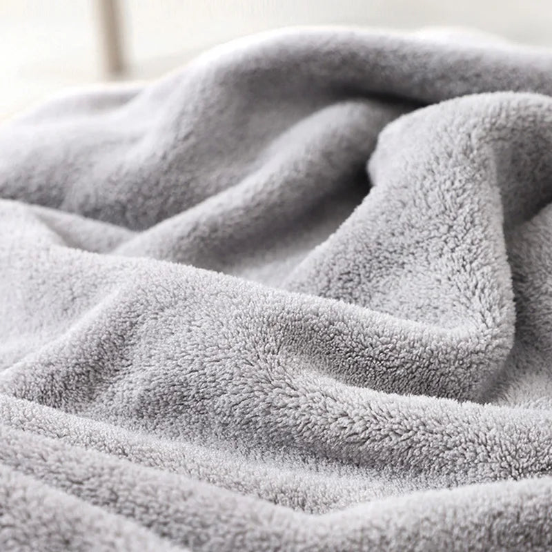 A soft gray hooded animal bath towel is draped and folded, showing its fluffy texture.
