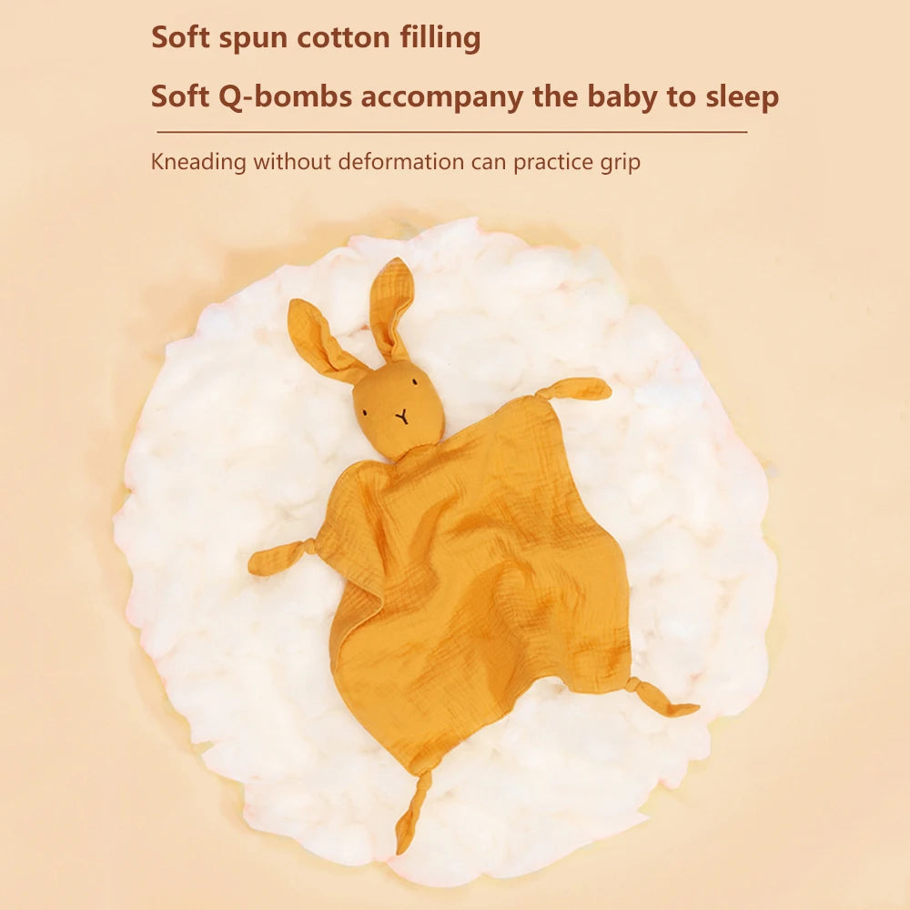 A golden rabbit stuffed with soft spun cotton filling lying on a white fluffy surface.