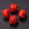 Several small, glossy red glass charms shaped like lily of the valley buds for jewelry making