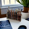 A wooden art brush and pencil organizer with 67 slots sits on a white desk next to a laptop.