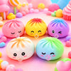 A collection of pink and yellow bubble-spitting dumpling squishy stress relief toys arranged on a pink surface.