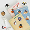 A collection of Halloween themed stickers featuring cats, pumpkins, and spooky characters on various colored paper.