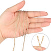 A hand holds several strands of natural jute twine for crafts and DIY projects.