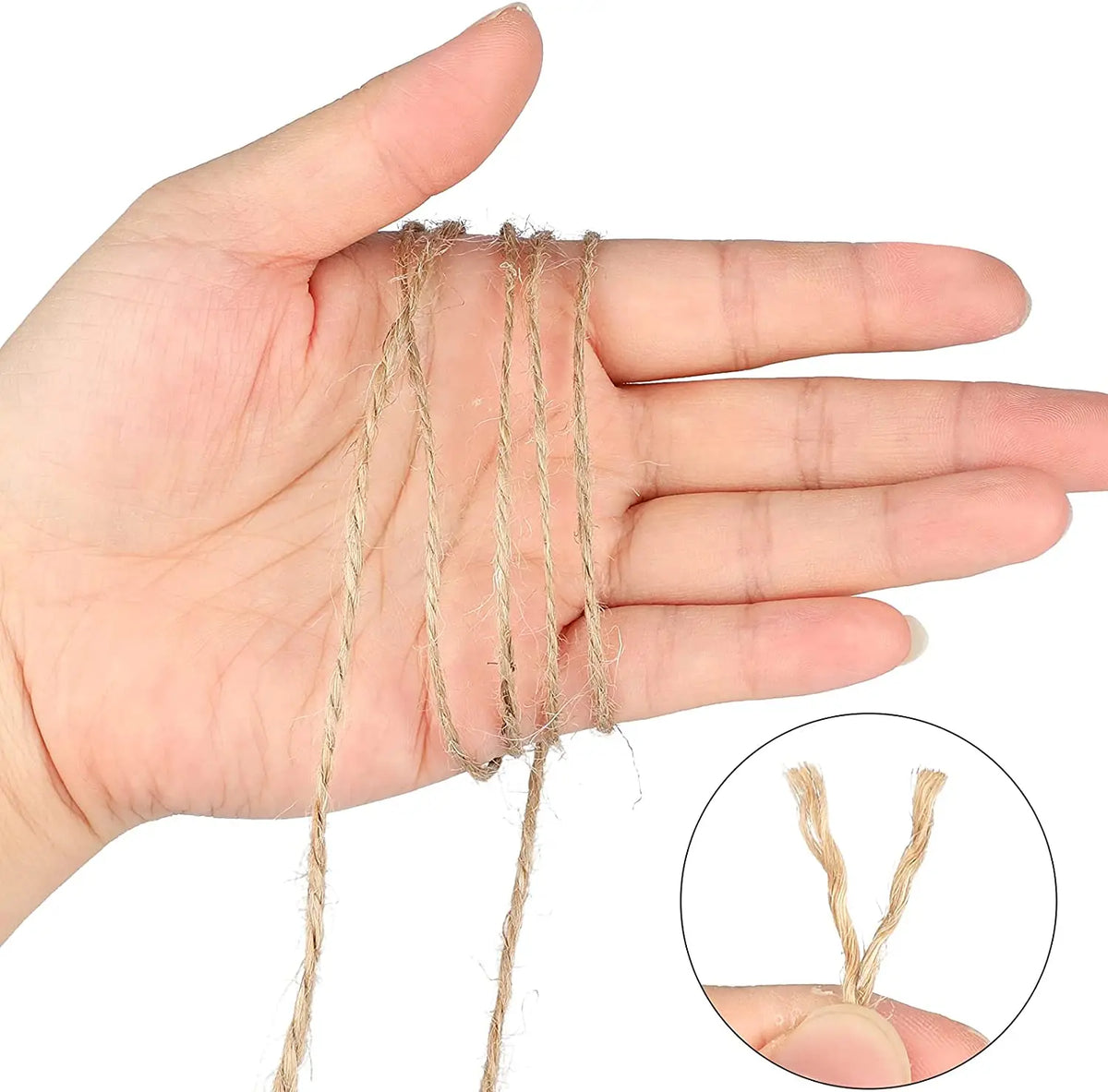 A hand holds several strands of natural jute twine for crafts and DIY projects.
