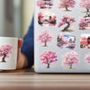 A close-up of a laptop featuring a sheet of watercolor peach blossom stickers depicting Japanese landscapes and trees.