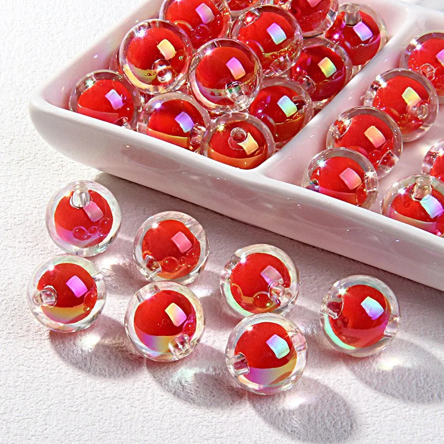 A collection of shiny red and pink acrylic craft beads arranged in a white dish.