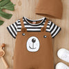 A brown baby bear print short sleeve romper and matching hat laid on a light wooden surface.