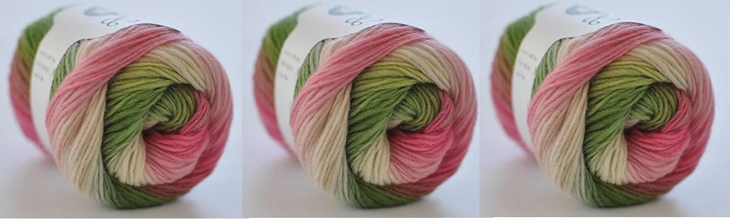 A ball of hand-dyed merino wool yarn in shades of pink, green, and cream, coiled for knitting or crochet.