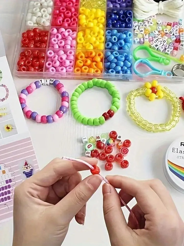 A hand is stringing a red bead onto a white string for a DIY bracelet making kit.