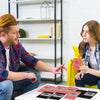 A close-up of couples scratch-off challenge cards for romantic date nights displayed on a white table.