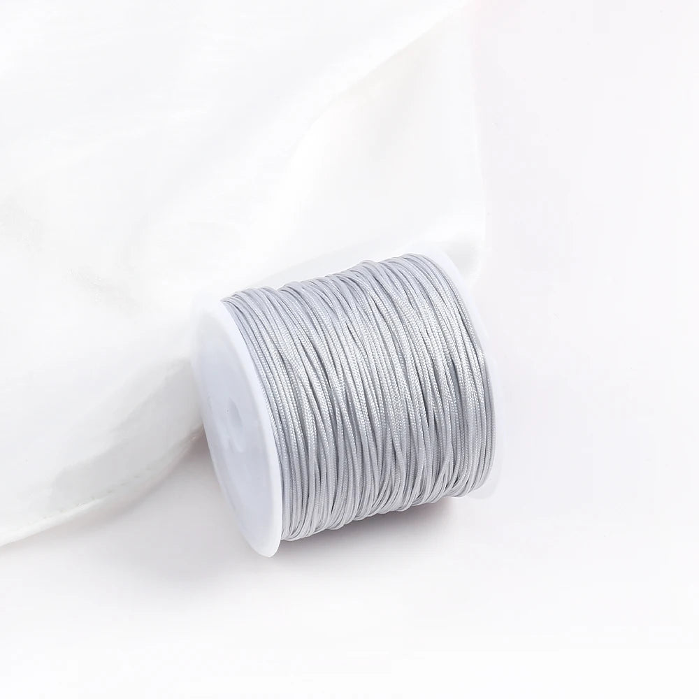 A roll of gray 0.8mm cotton nylon macrame cord for jewelry making and crafts.