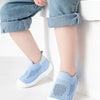 A pair of light blue breathable mesh slip-on sneakers for toddlers resting on a white surface.