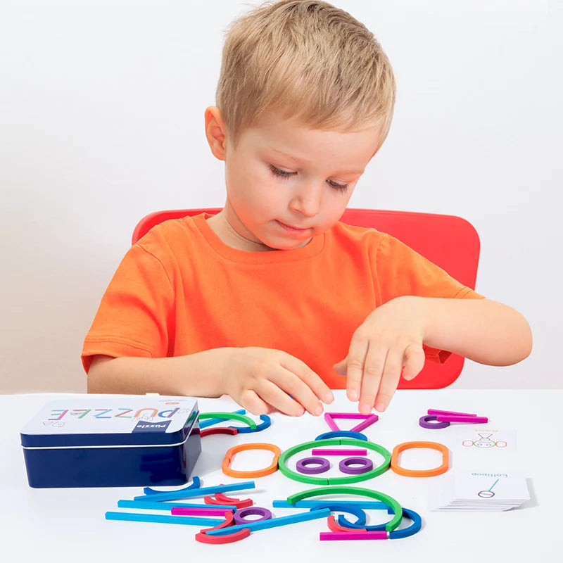 A young boy is sorting wooden shape puzzle pieces like rings and cutouts on a white table.
