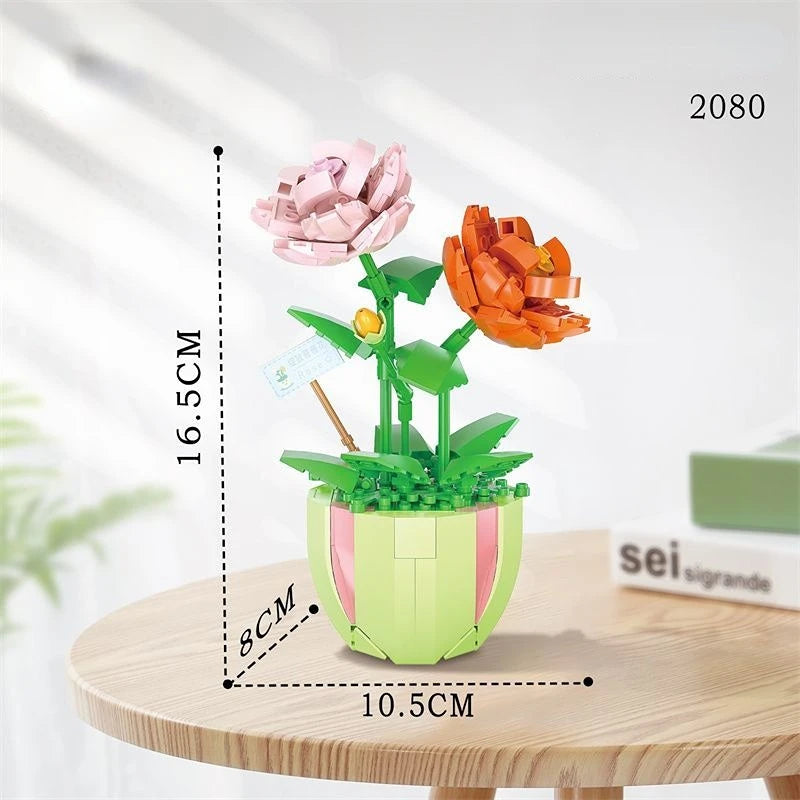 A set of floral building blocks featuring pink and orange flowers displayed in a green pot.
