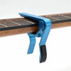 A blue aluminum alloy quick-change guitar capo clamped onto a wooden fretboard.