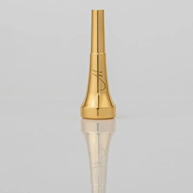 A gold-plated trumpet mouthpiece with a tapered design and an engraved signature.