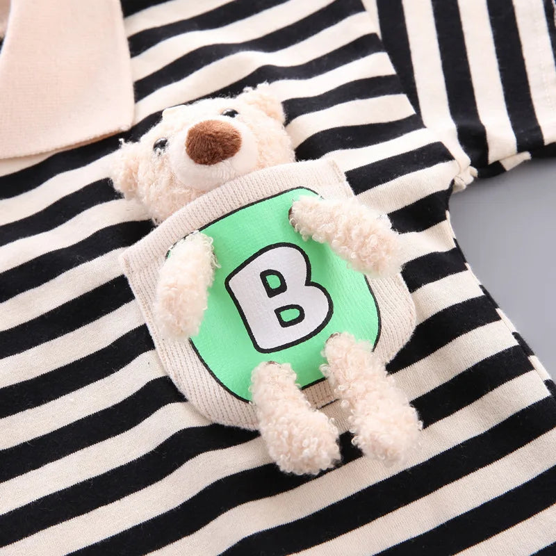 A white and black striped outfit featuring a teddy bear appliqué on the chest.