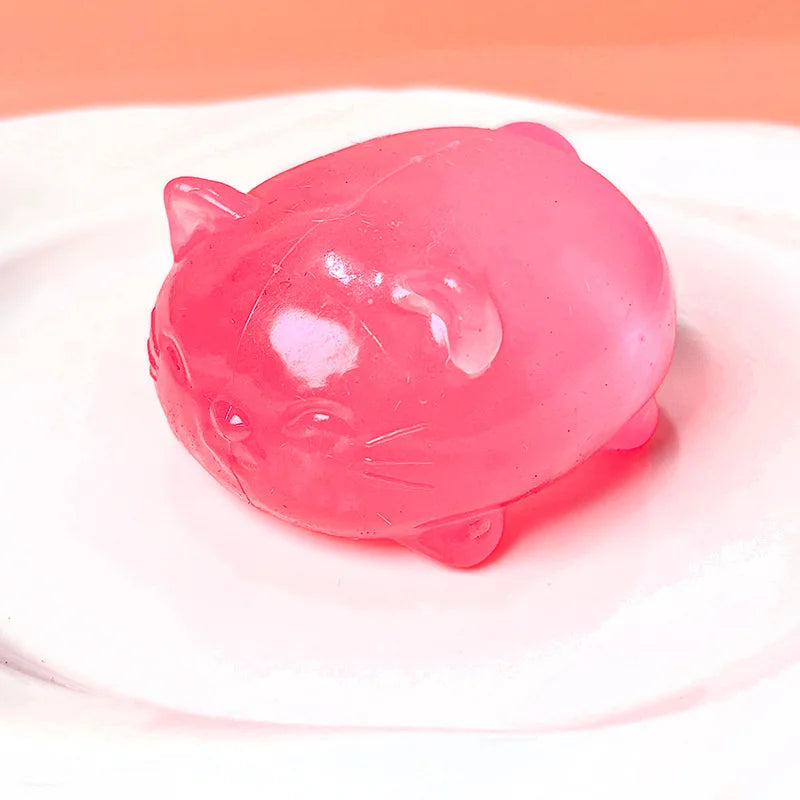 A translucent pink cat squishy toy resting on a white surface.