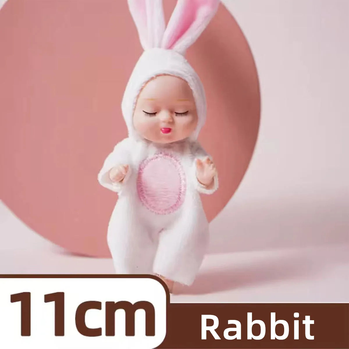 A white rabbit-themed mini reborn baby doll with pink ears and soft clothing.