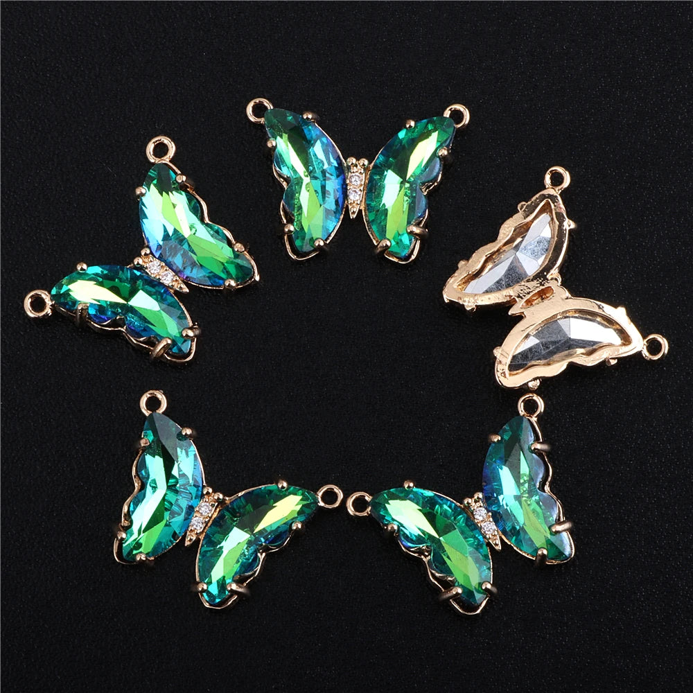 A set of gold-toned crystal butterfly charm beads for jewelry making, featuring iridescent green and blue butterfly shapes.