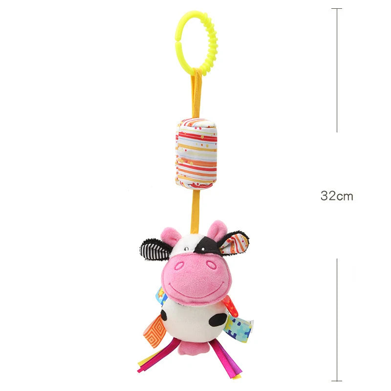 A pink and white plush animal hanging rattle toy with a yellow ring and striped fabric.
