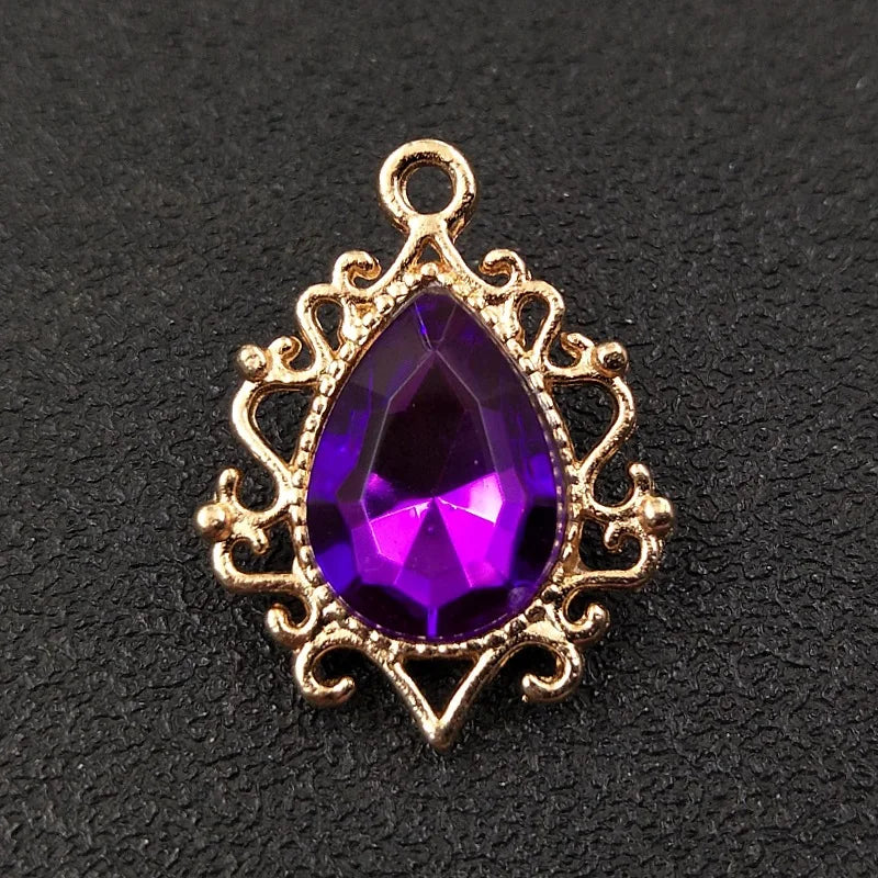 Gold plated water droplet charm featuring a purple crystal rhinestone set in an ornate flower design.